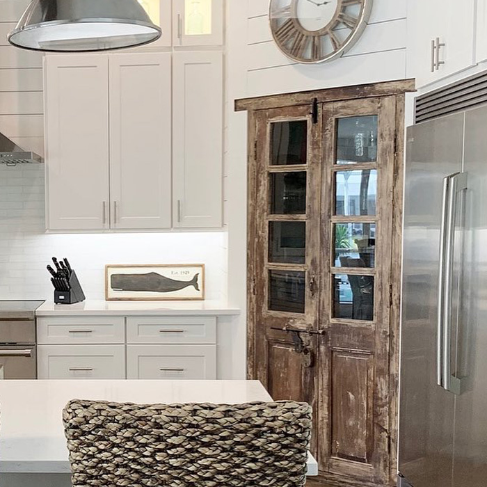 Kitchen with white kitchen cabinets and a pantry door in the corner 