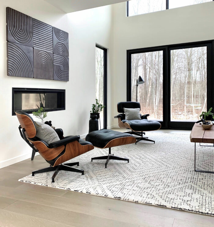Black leather padded armchair near black wooden framed glass window in a modern living room with Sherwin-Williams paint colors.