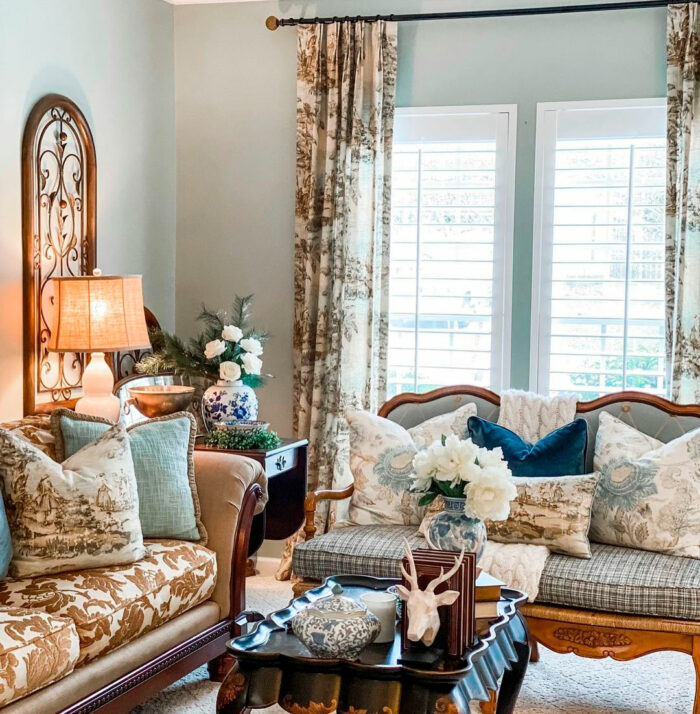 Cozy living room featuring Sherwin-Williams paint colors with vintage lamp on table near patterned sofas and pillows.