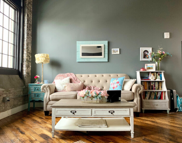 White wooden layered drawer beside white couch in living room showcasing Sherwin-Williams paint colors popular in 2024.