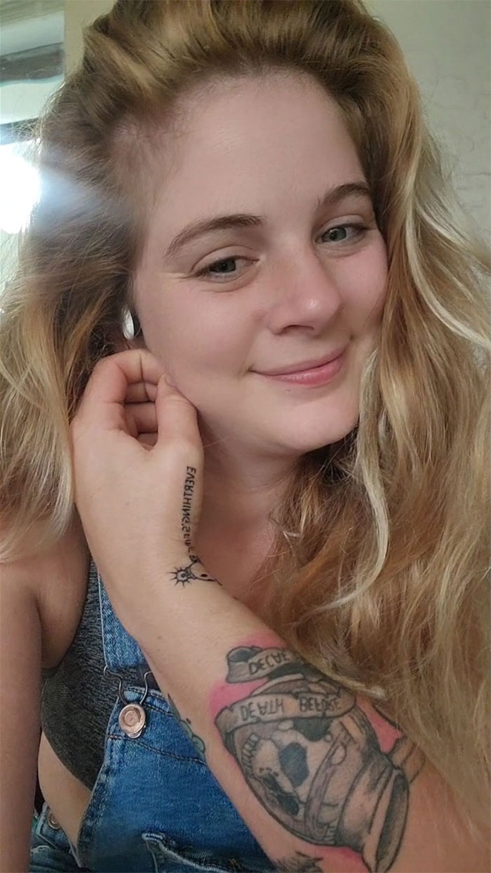 Smiling woman showing tattoo blunder on arm, linked to viral TikTok and artist&rsquo;s existential crisis.