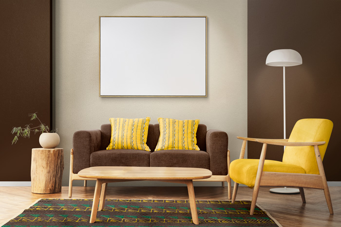 Brown couch with yellow pillows beside a yellow chair in a warm color scheme living room decor setting. Brown couch with yellow pillows beside a yellow chair in a warm color scheme living room decor setting.