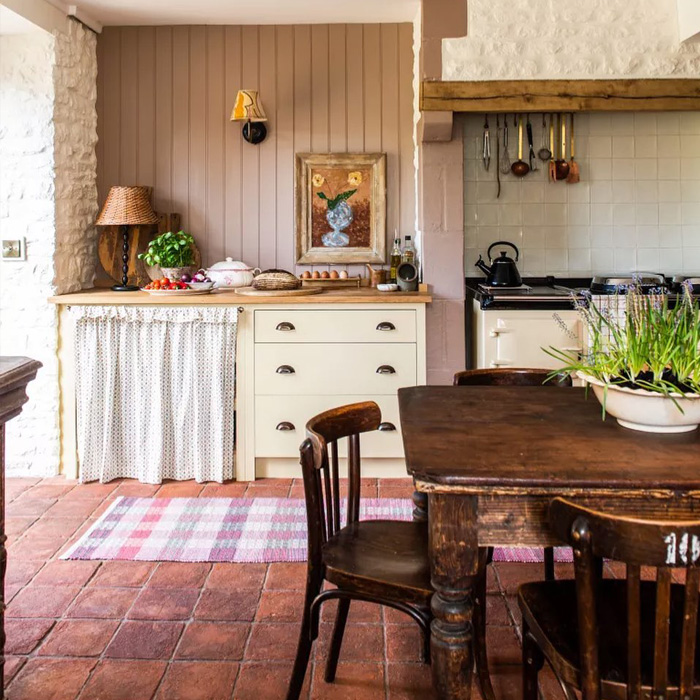 Brown dining table on terracotta tiles creating warm colors in a cozy kitchen with rustic decor elements. Brown dining table on terracotta tiles creating warm colors in a cozy kitchen with rustic decor elements.
