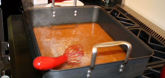 Close-up of a red whisk in a large pan with liquid on a stovetop, illustrating cooking fails from an online community forum.