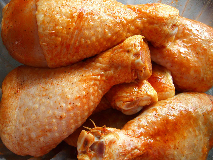 Seasoned raw chicken drumsticks in a bowl, representing an online community forum about cooking fails shared by users.