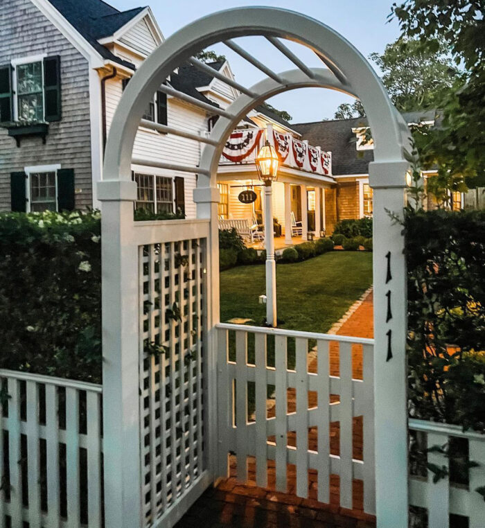 white picket fence with a rounded arch in front of a house white picket fence with a rounded arch in front of a house
