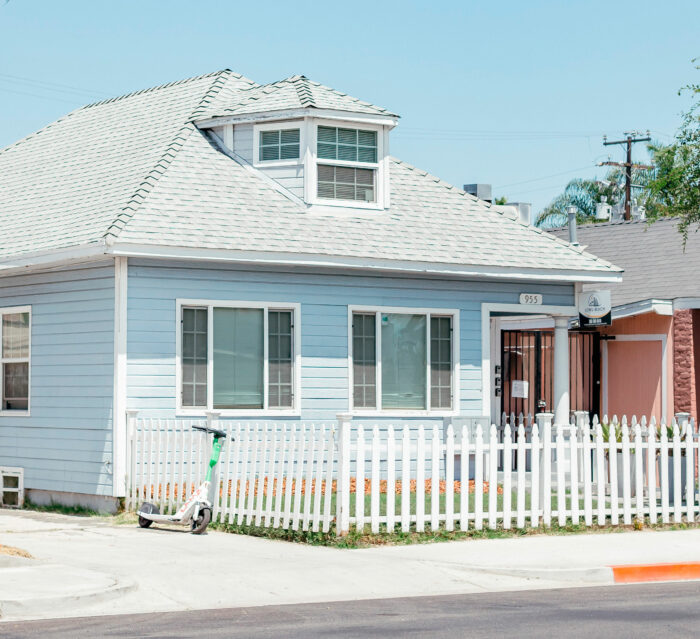 Light blue house with a white wraparound picket fence Light blue house with a white wraparound picket fence