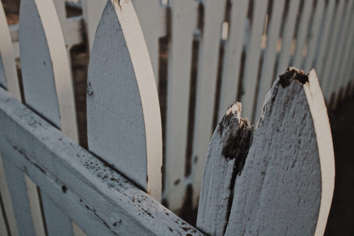 Damaged white wooden picket fence Damaged white wooden picket fence