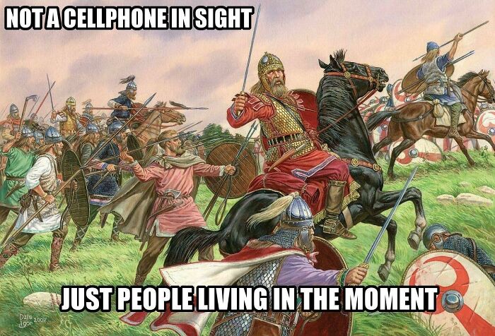 Medieval meme showing a chaotic battle scene with warriors on horseback, humor text about living in the moment without cellphones.