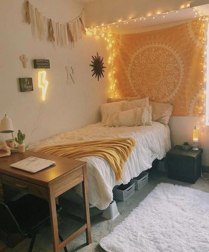 Bright bedroom featuring a yellow linen tapestry wall art with cozy bedding and warm string lights for a stylish space.