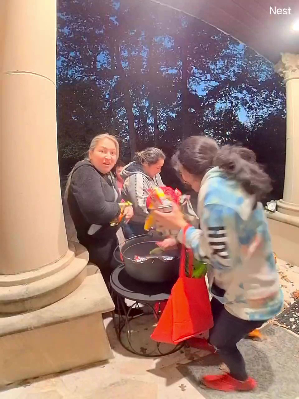 Family taking Halloween candy quickly from a large bowl on porch during evening trick or treating. Family taking Halloween candy quickly from a large bowl on porch during evening trick or treating.