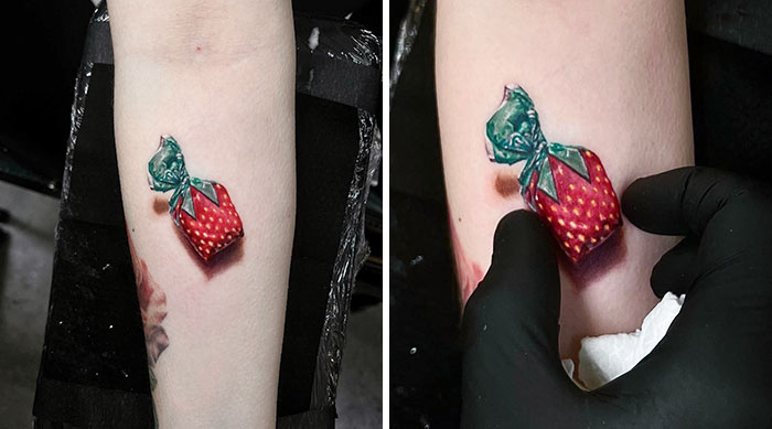 3D tattoo of a strawberry candy wrapper on an arm, showcasing realistic detail and vibrant colors.
