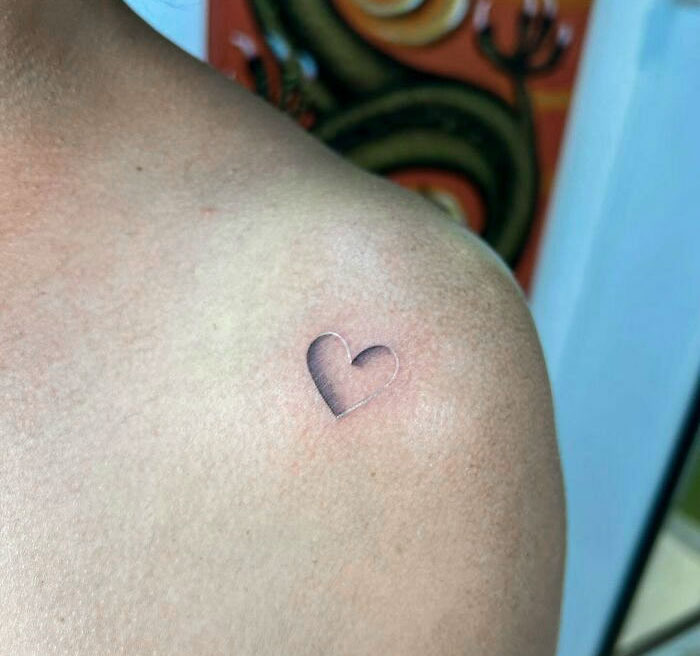 3D tattoo of a small heart on a person's shoulder showcasing intricate shadow details.