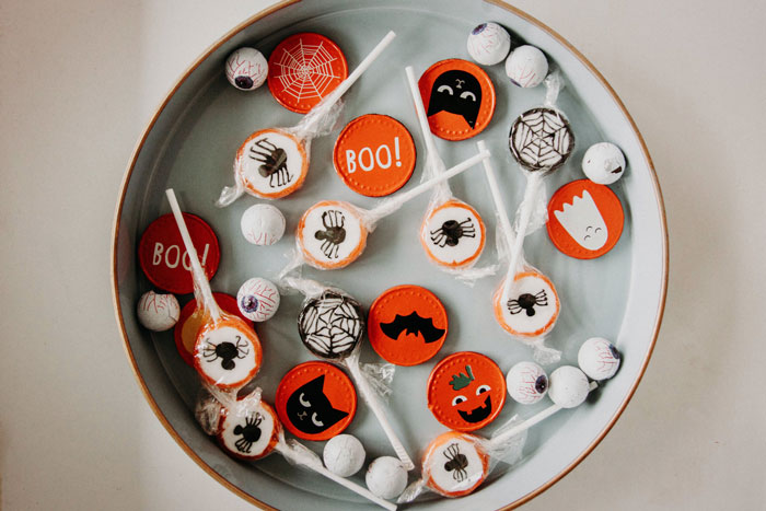 Halloween candy with spooky designs including spiders, bats, and pumpkins arranged on a plate for trick or treaters. Halloween candy with spooky designs including spiders, bats, and pumpkins arranged on a plate for trick or treaters.
