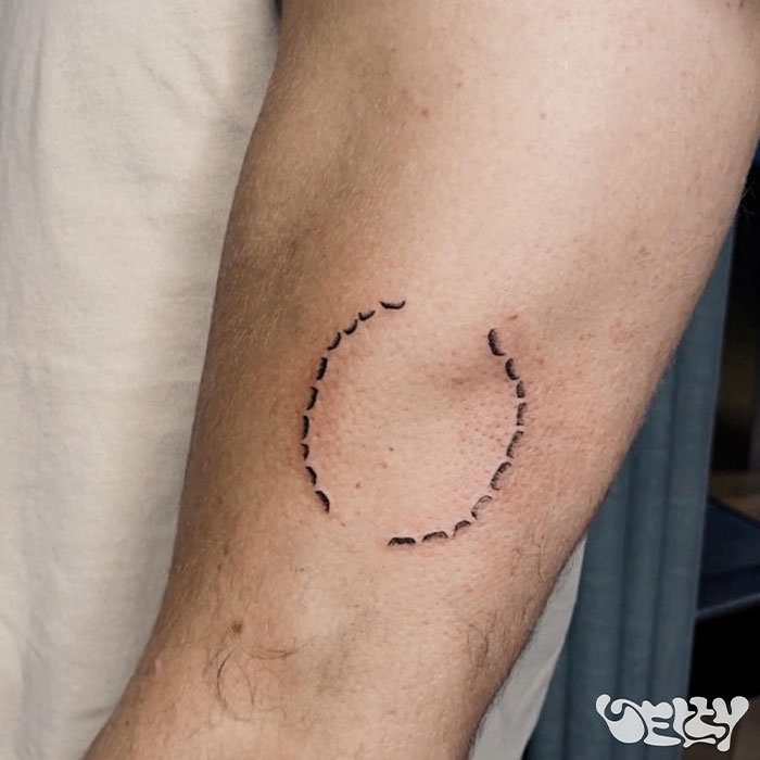 Man's arm showing a minimal circle tattoo symbolizing love for girlfriend.