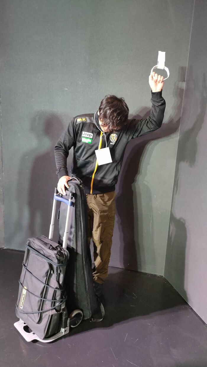 A Band Member Riding A Crowded Train With A Large Luggage, Feeling Cramped