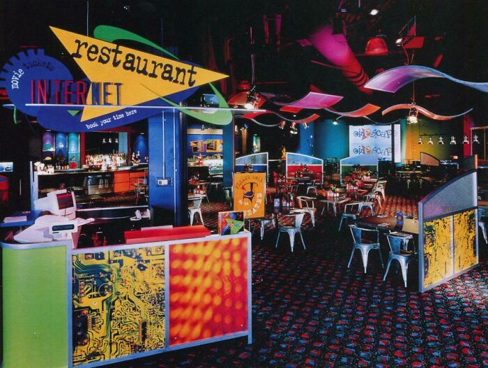 Colorful '90s-themed restaurant interior with bright signs and retro decor, evoking nostalgia for the Internet era.
