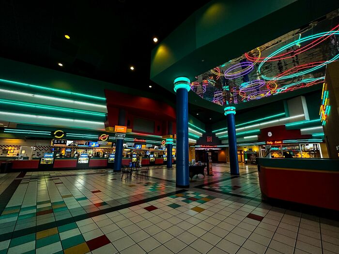 90s-themed movie theater lobby with neon lights and colorful decor, evoking nostalgia.