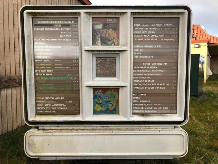 Retro drive-thru menu from the '90s featuring burgers, fries, and drinks against a nostalgic outdoor setting.