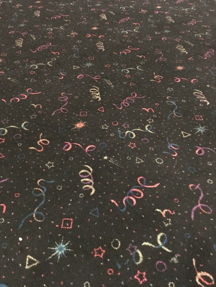Dark '90s carpet with colorful, nostalgic geometric patterns and swirls.