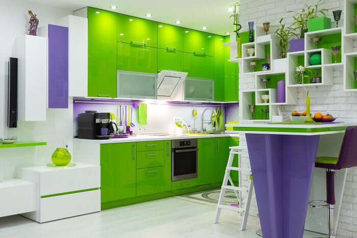Modern kitchen with glossy green kitchen cabinets paired with white walls and purple accents for a fresh natural color scheme