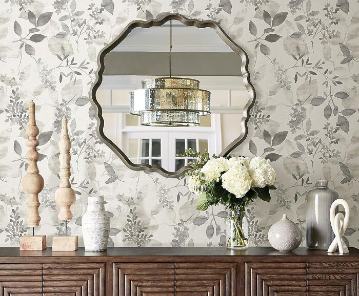 Room with gray flower wallpaper mirror and cupboard
