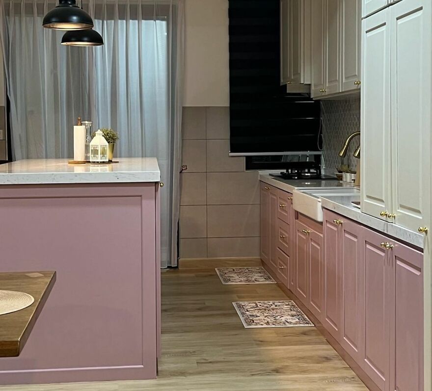 Pink and white modern kitchen cabinets with gold handles and marble countertops in a stylish kitchen renovation design.