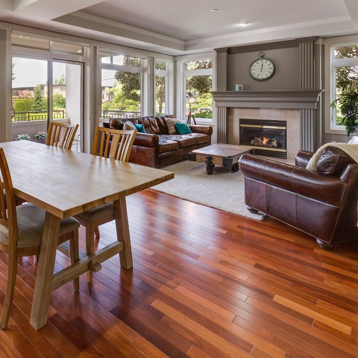 Dining room with wooden table, chairs, leather sofas, and fireplace creating inspiring dining room ideas.