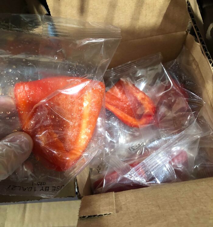 Red bell pepper slices individually wrapped in plastic inside a cardboard box showing packaging fails.