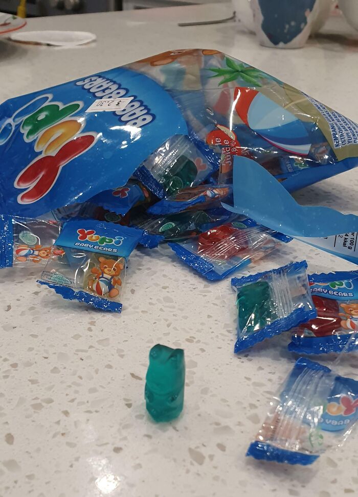 Packaging fail showing a large gummy bears bag with individually wrapped gummies spilling out on a countertop.