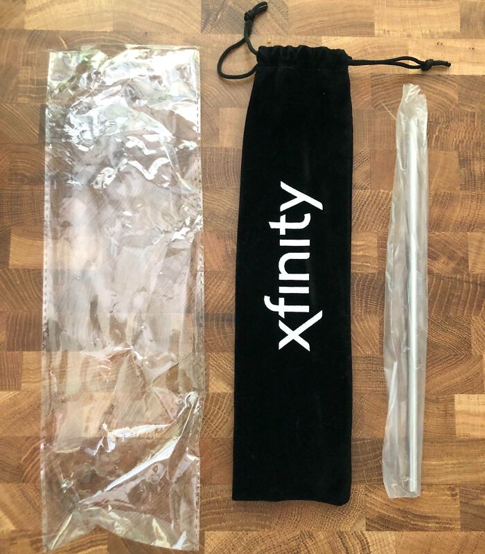 Plastic straw in oversized velvet pouch alongside its large plastic outer packaging, showing a facepalm-worthy packaging fail.