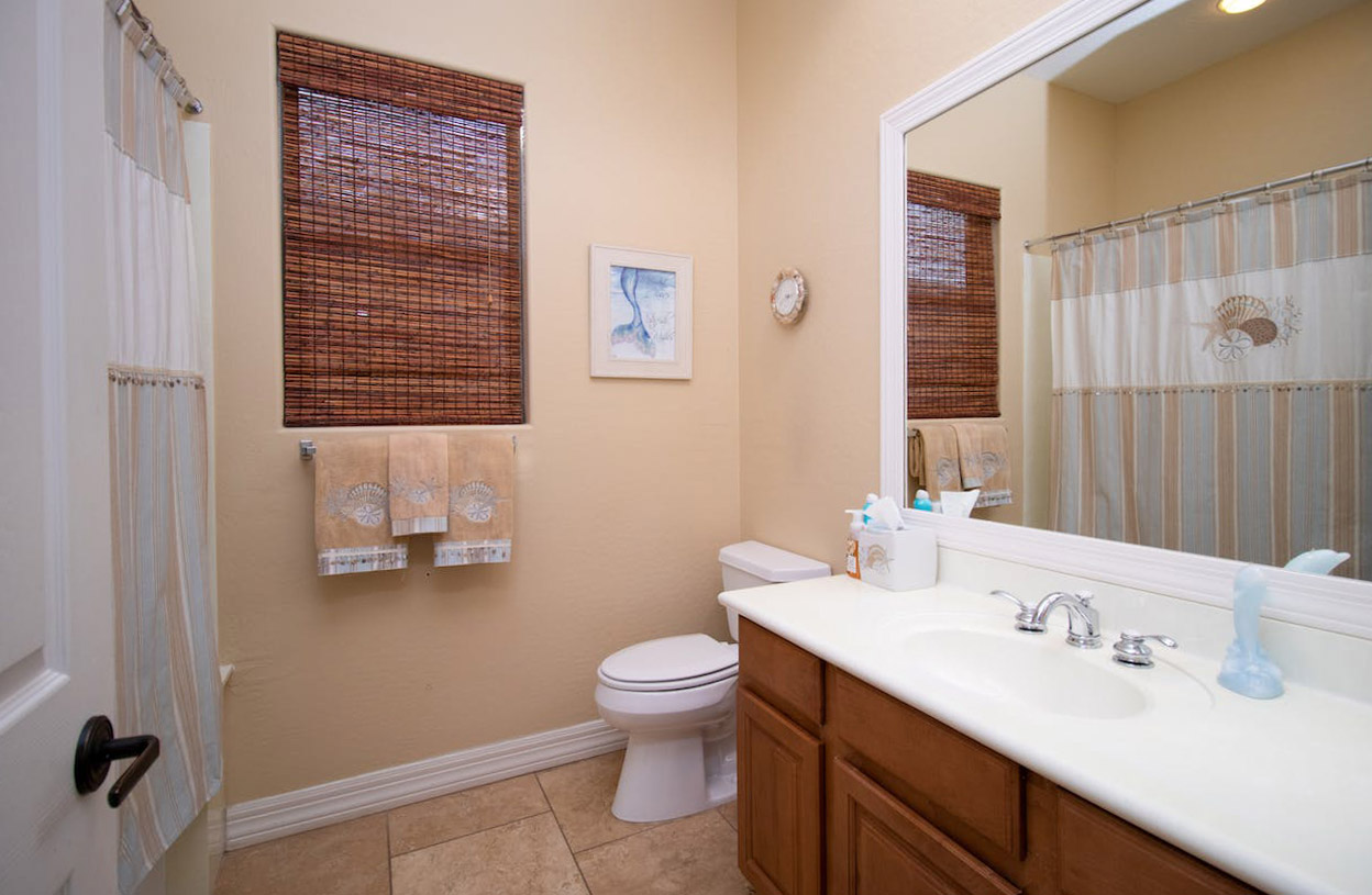 Light pastel orange bathroom with wooden cabinets and mirror