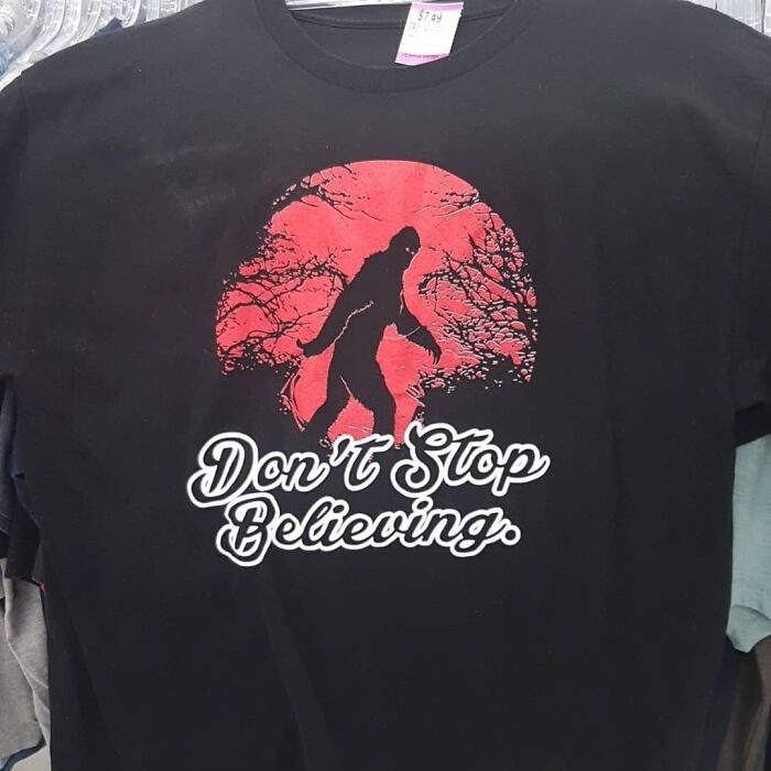 Black t-shirt with red moon and Bigfoot silhouette above text promoting unusual thrift store donations on Instagram.