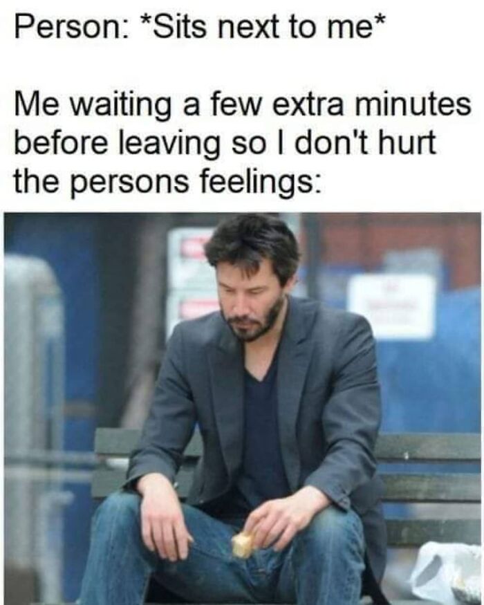 Man sitting alone on a bench with a sandwich, looking down, related to funny and relatable socially awkward memes.