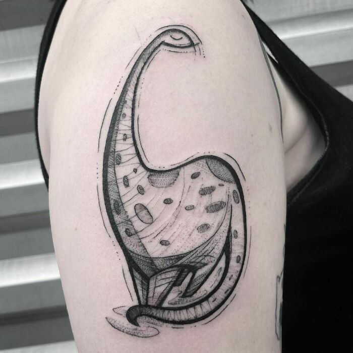 Minimalist dinosaur tattoo on a person's upper arm, featuring a unique dotwork and line art style.