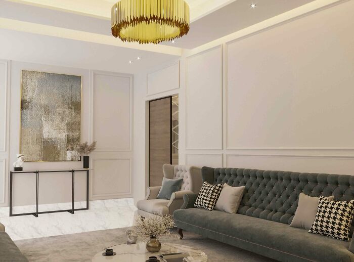 Spacious living room featuring tall wainscoting panels, a large gray sofa, armchair, and a modern yellow chandelier.