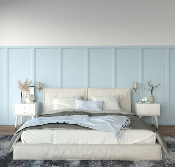 Bedroom featuring pastel blue wainscoting panels and white walls in a modern, minimalist design.