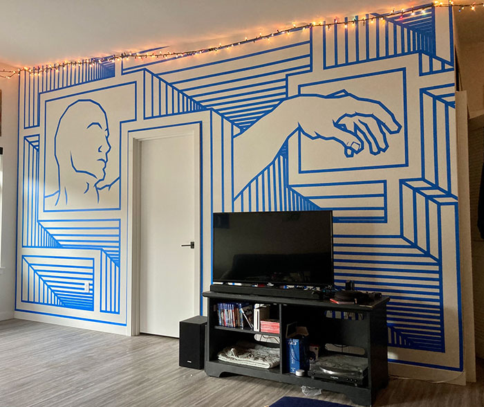 Wall-to-wall mural with creative blue line art depicting a face and hand, showcasing easy and creative wall art ideas.