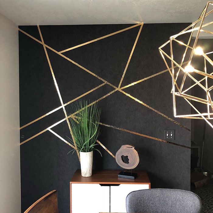 Accent wall design featuring gold geometric lines and modern decor, showcasing creative wall art ideas for a stylish space.