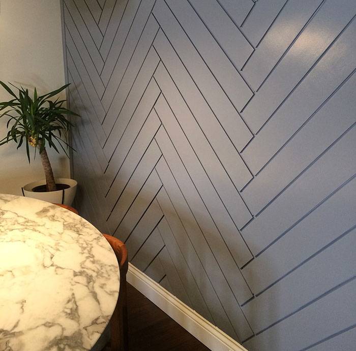 Blue framed wood shims arranged in a herringbone pattern wall art creating a stylish decorative space.