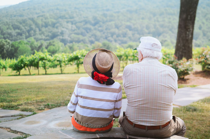 Old man and a woman sitting near a mountain 