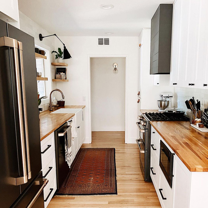 Kitchen with white cabinets and black fridge featuring butcher block countertops for classic charm and durability. Kitchen with white cabinets and black fridge featuring butcher block countertops for classic charm and durability.