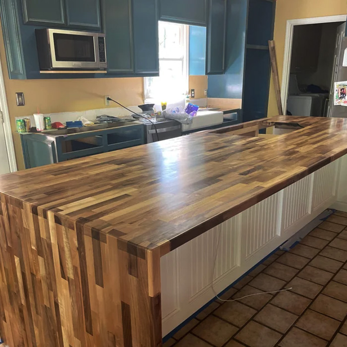 Butcher block countertop being installed in a kitchen, showcasing timeless durability and classic charm with wood grain finish Butcher block countertop being installed in a kitchen, showcasing timeless durability and classic charm with wood grain finish