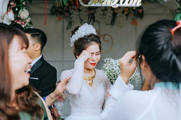 Bride in wedding dress crying while guests interact, highlighting moments that made people think a divorce was coming at weddings.