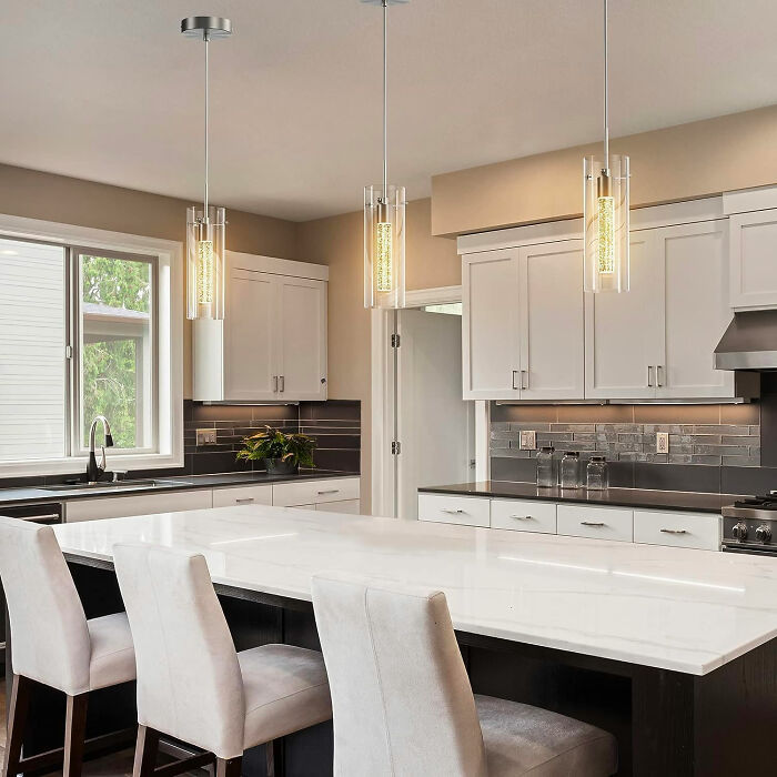 White dining room with modern white chairs and pendant lights, showcasing inspiring dining room ideas for family gatherings.
