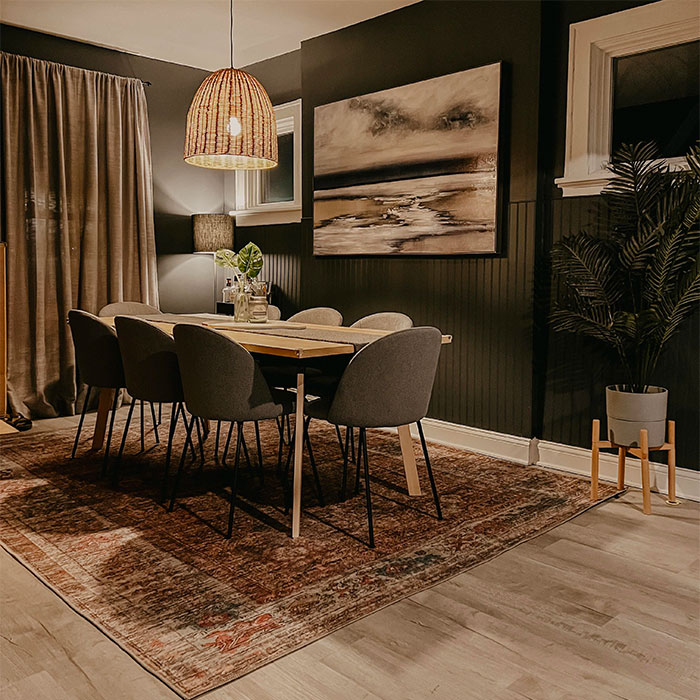 Black dining room with wooden table and chairs, featuring cozy lighting and elegant dining room ideas for family gatherings.