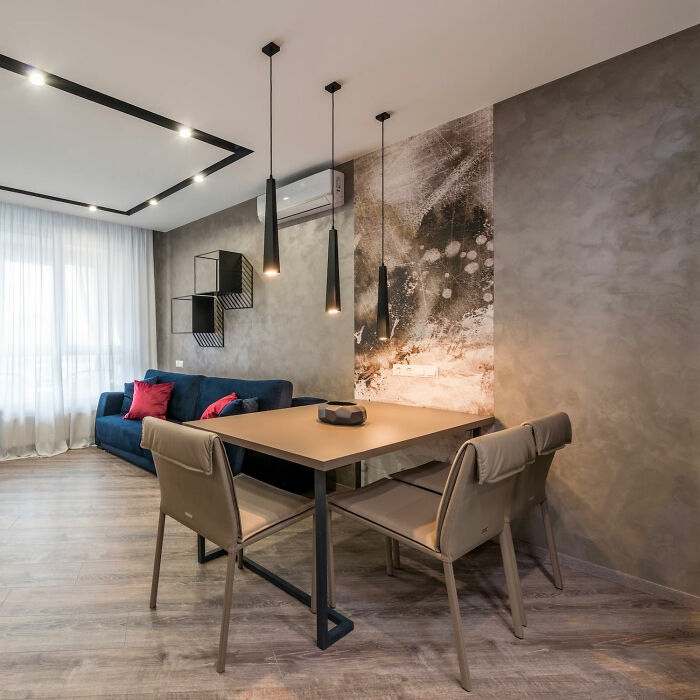 Gray dining room with wooden table and chairs, modern pendant lights, and artwork creating inspiring dining room ideas ambiance.