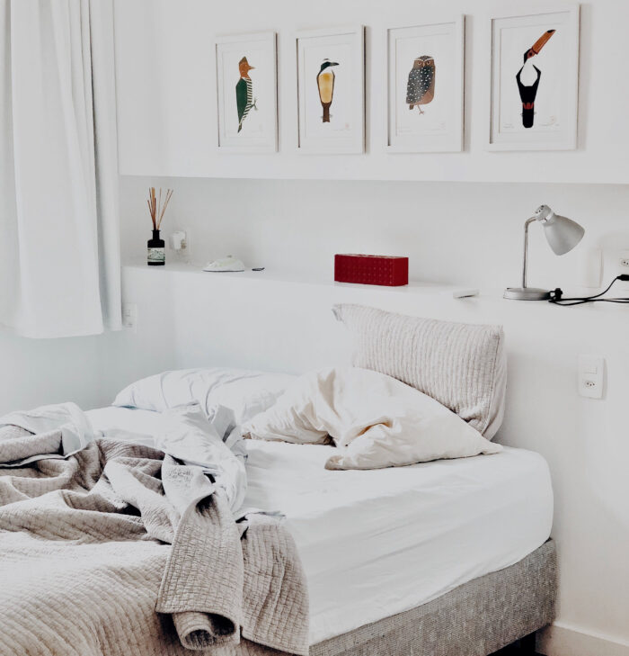 Pictures hanging on the wall in a white bedroom