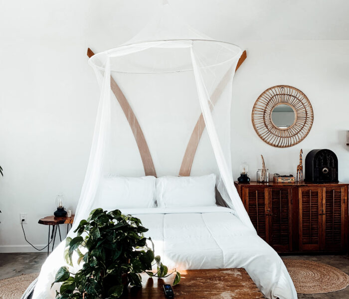 White bed with white bed linen and canopy
