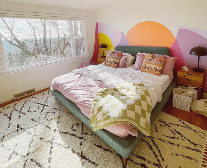 big bed near the wall with mural